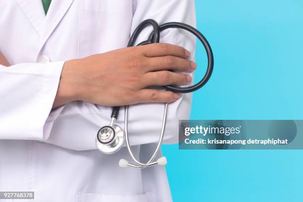 male doctor holding a stethoscope - stethoskop stock-fotos und bilder