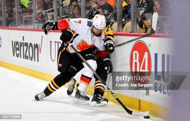 Brodie of the Calgary Flames handles the puck against Patric Hornqvist of the Pittsburgh Penguins at PPG Paints Arena on March 5, 2018 in Pittsburgh,...