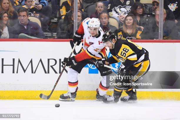 Calgary Flames Center Sean Monahan and Pittsburgh Penguins Defenseman Kris Letang go for the puck during the first period in the NHL game between the...