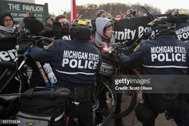 Demonstrators clash with police before the start of a speech by white nationalist Richard Spencer, who popularized the term 'alt-right', at Michigan...