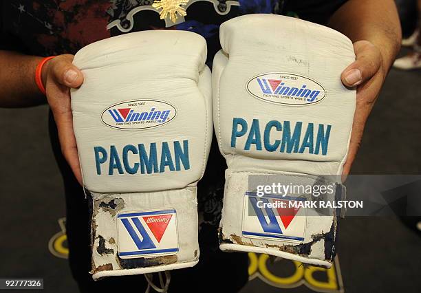 Trainer shows the gloves of Welterweight boxing champion Manny "PacMan" Pacquiao of the Philippines, as he prepares for his fight against Miguel...