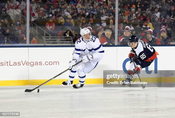 Nikita Zaitsev of the Toronto Maple Leafs looks to make a pass play as Andre Burakovsky of the Washington Capitals pursues the play during the 2018...