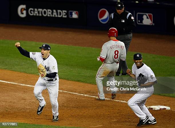 Mark Teixeira and Mariano Rivera of the New York Yankees celebrate after against Shane Victorino of the Philadelphia Phillies grounded out for the...