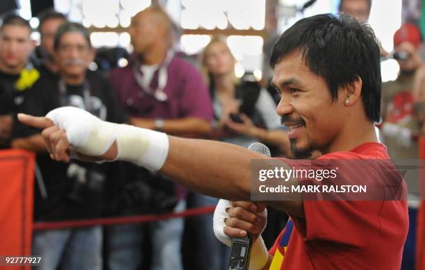 Welterweight boxing champion Manny "PacMan" Pacquiao of the Philippines, jokes with reporters as he prepares for his fight against Miguel Cotto, at...