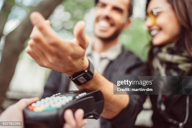 man betalen contactloos met smartwatch - smartwatch stockfoto's en -beelden