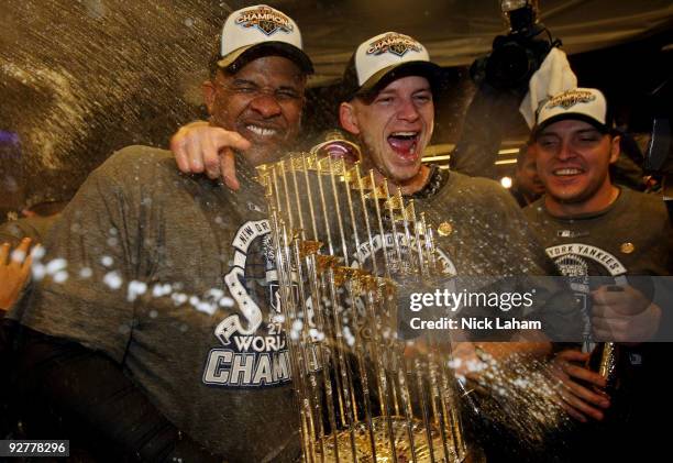 Sabthia, A.J. Burnett and Eric Hinske of the New York Yankees celebrate with the trophy in the locker room after their 7-3 win against the...