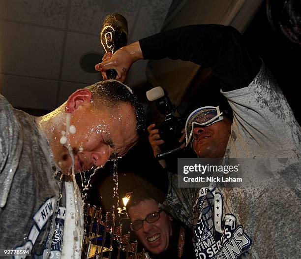 Alex Rodriguez and Melky Cabrera of the New York Yankees celebrate in the locker room with the trophy after their 7-3 win against the Philadelphia...