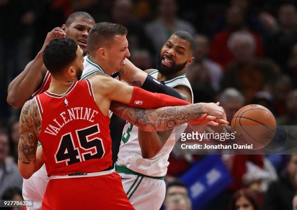 Daniel Theis of the Boston Celtics battles for the ball with Denzel Valentine and Cristiano Felicio of the Chicago Bulls at the United Center on...