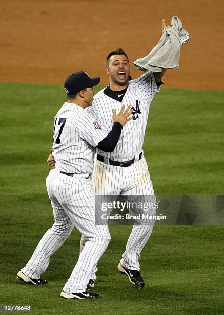 Jerry Hairston Jr. #17 and Nick Swisher of the New York Yankees celebrate after their 7-3 win against the Philadelphia Phillies in Game Six of the...