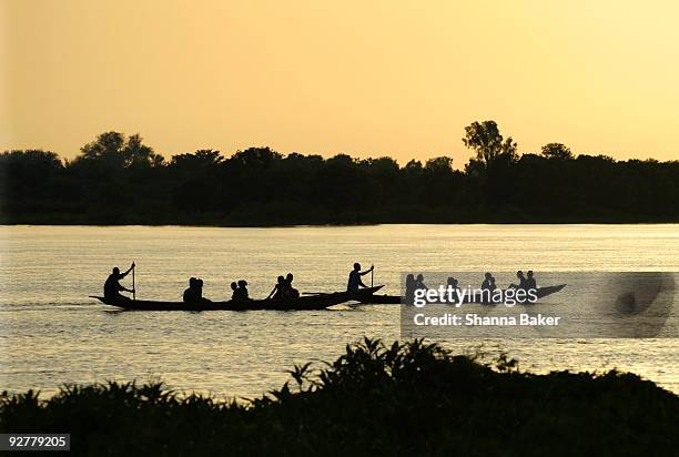 paddling on the niger river at sunset - niger river foto e immagini stock