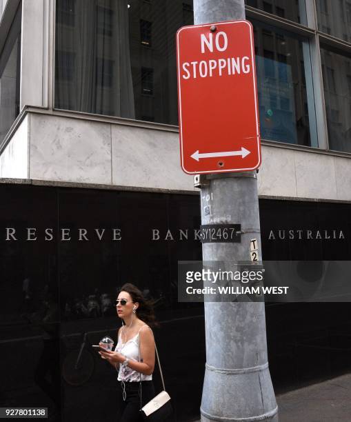 Woman walks past the Reserve Bank of Australia building in Sydney on March 6 as Australia's central bank kept interest rates at a record in a widely...