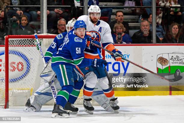 Troy Stecher of the Vancouver Canucks checks Andrew Ladd of the New York Islanders during their NHL game at Rogers Arena March 5, 2018 in Vancouver,...