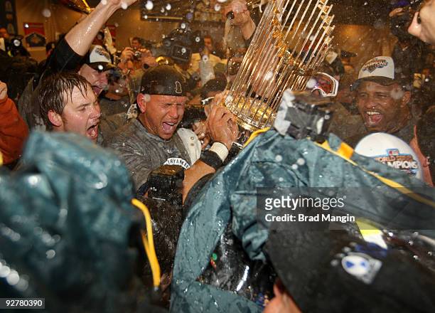 Alex Rodriguez and C.C. Sabathia of the New York Yankees celebrate with the World Series trophy in the locker room after their 7-3 win over the...