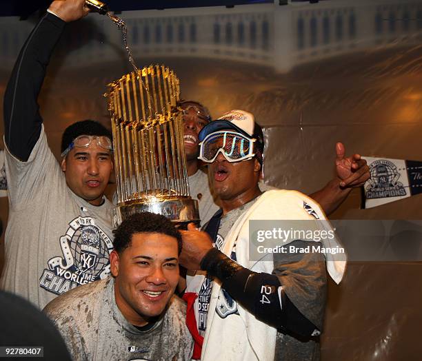 Jose Molina, Melky Cabrera and Robinson Cano of the New York Yankees celebrate in the locker room after their 7-3 win over the Philadelphia Phillies...