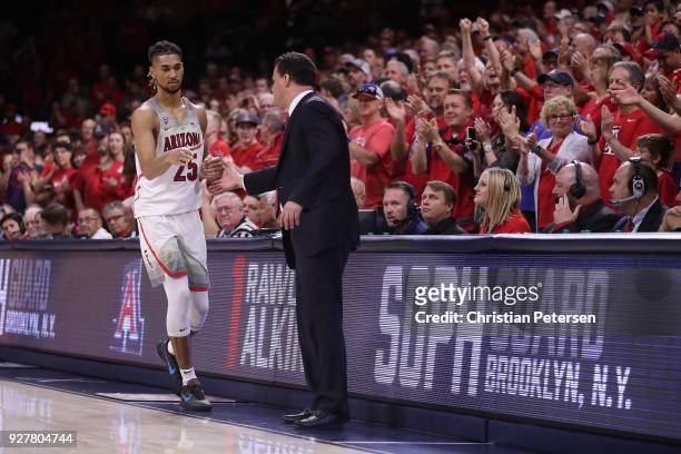 Head coach Sean Miller of the Arizona Wildcats greets Keanu Pinder after Pinder checked out of the second half of the college basketball game against...