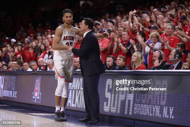 Head coach Sean Miller of the Arizona Wildcats greets Keanu Pinder after Pinder checked out of the second half of the college basketball game against...