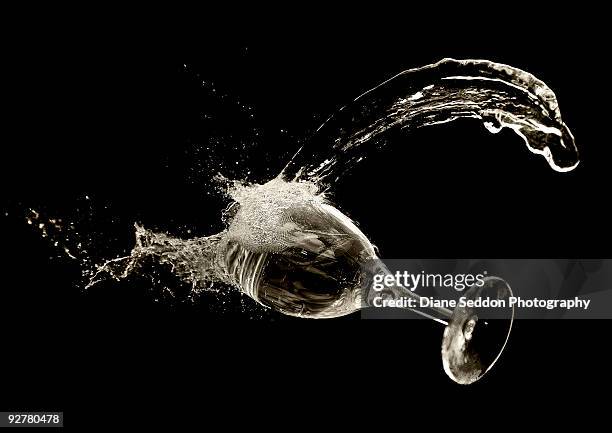 liquid spilling from a wine glass - wine glass on black stock pictures, royalty-free photos & images