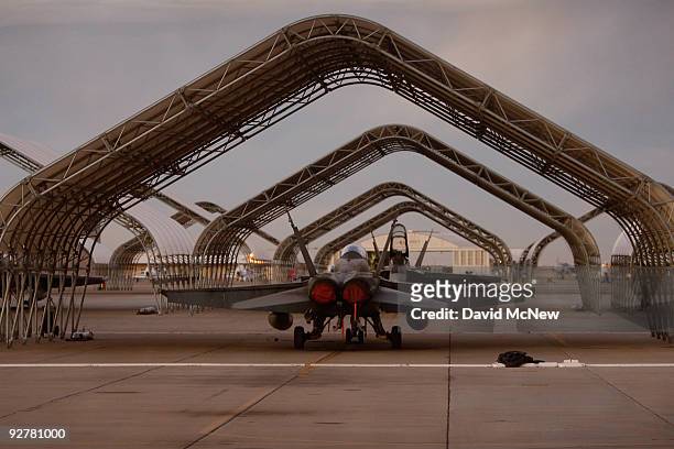 Hornet fighter jets belonging to the Canadian 410 'Couger' Squadron are seen under shelters on the tarmac at Naval Air Facility El Centro on November...