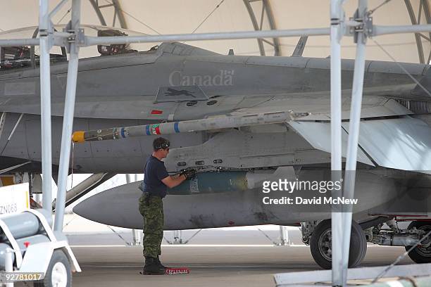 Weapons are loaded onto a CF-18 Hornet fighter jet belonging to the Canadian 410 'Couger' Squadron at Naval Air Facility El Centro on November 4,...