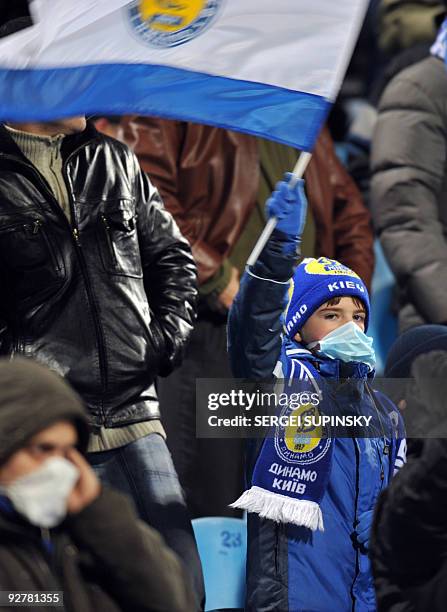 Picture taken on November 4, 2009 shows a young fan of FC Dynamo, wearing a protective mask, waving a flag during a UEFA Champions League match,...