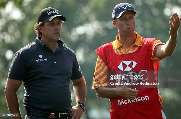 Phil Mickelson of the USA waits with his caddie Jim "Bones" Mackay on the 12th hole during the first round of the WGC-HSBC Champions at Sheshan...
