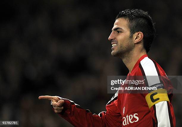 Arsenal's Spanish midfielder Cesc Fabregas points to a teammate after scoring the third goal against AZ Alkmaar during the Champions League Group H...