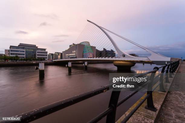 samuel beckett bridge in dublin with liffey river and city skyline (dublin/ ireland) - convention centre dublin stock pictures, royalty-free photos & images