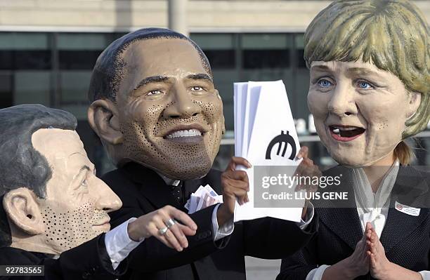 Members of anty-poverty group Oxfam wearing masks of world leaders French President Nicolas Sarkozy, US President Barack Obama, and German Chancellor...