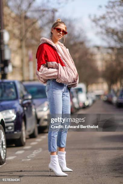 Lena Perminova wears a red and pink bomber jacket, cropped jeans, white shoes, sunglasses, outside Giambattista Valli, during Paris Fashion Week...