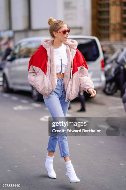 Lena Perminova wears a red and pink bomber jacket, cropped jeans, white shoes, sunglasses, outside Giambattista Valli, during Paris Fashion Week...