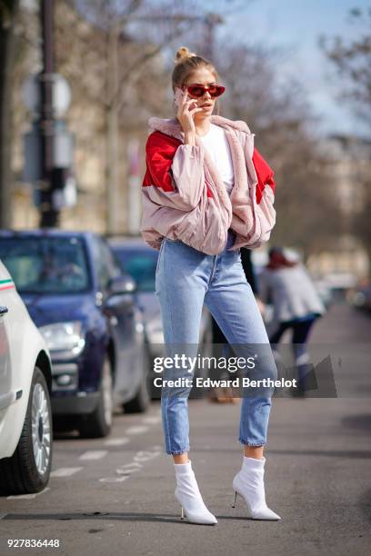 Lena Perminova wears a red and pink bomber jacket, cropped jeans, white shoes, sunglasses, outside Giambattista Valli, during Paris Fashion Week...