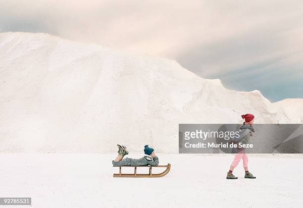 children traveling on sledge - family in snow mountain stock-fotos und bilder
