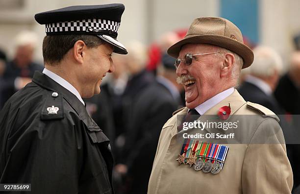 An ex-serviceman chats to a policeman outside Westminster Abbey at the official opening of the Royal British Legion's Field of Remembrance on...