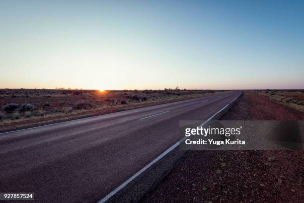 sunrise on the horizon over the country road in the outback - country road stock pictures, royalty-free photos & images
