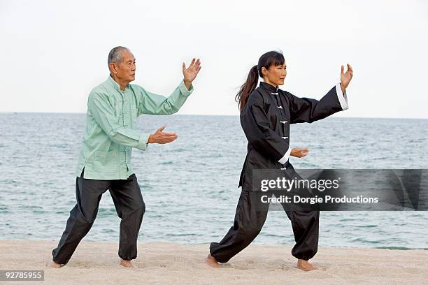 asian man and woman practising tai chi - tai chi stock pictures, royalty-free photos & images