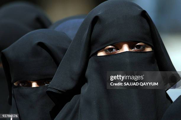 Pakistani women queue at a security checkpoint outside the Red Mosque in Islamabad on July 7, 2009. More than 1,000 Islamist hardliners gathered amid...