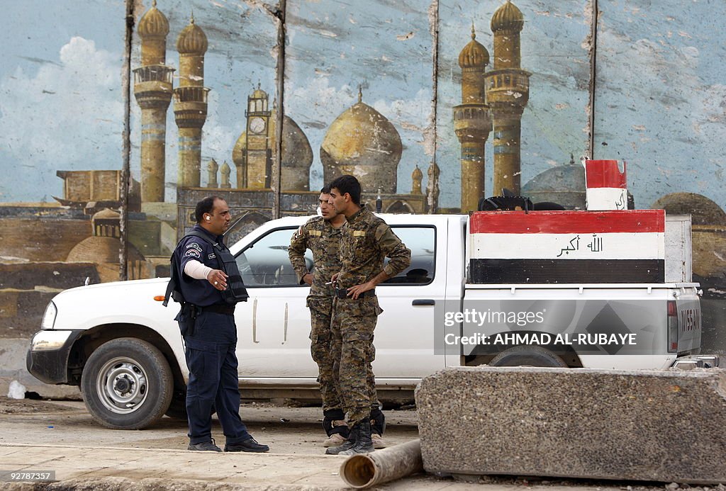 Iraqi security stand in front of painted