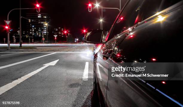 black german car drives through the city of munich - stopping at red traffic lights - auto ampel stock-fotos und bilder