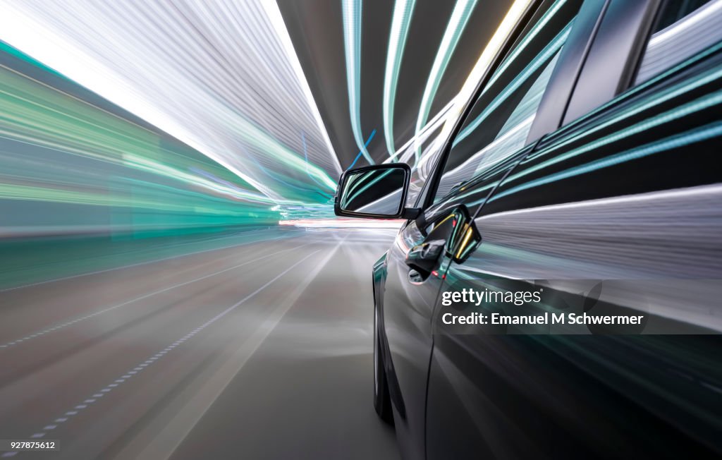 Black German car drives through a modern tunnel