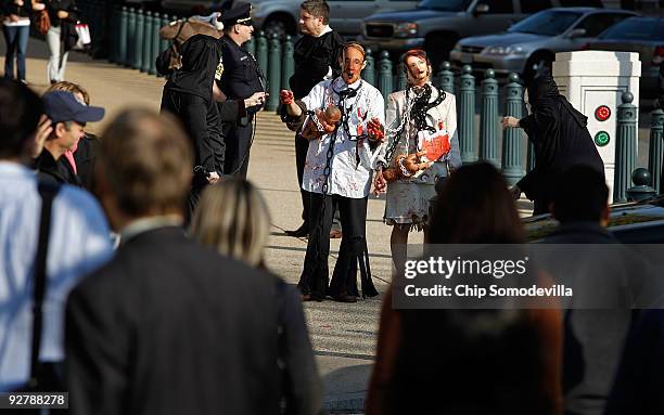 Anti-abortion demonstrators Diana Roccograndi of Wilkes-Barre, Pennsylvania, and Albert Stecklein of Bethesda, Maryland, wear paper masks of Speaker...