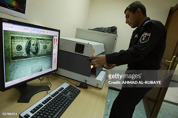 Member of Iraq's Crime Scene Investigation unit examines a 100-dollar bill at a laboratory at the Baghdad police academy on October 21, 2009. Still...