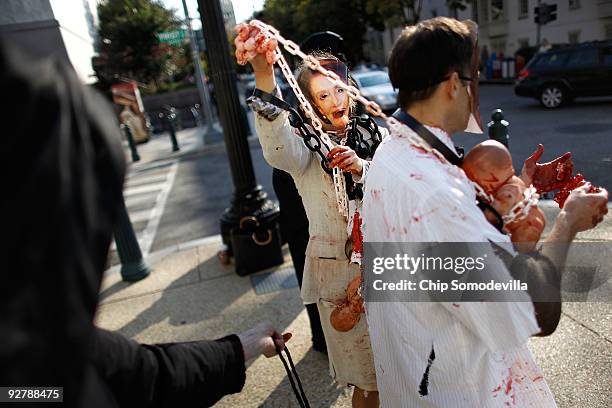 Anti-abortion demonstrator Diana Roccograndi of Wilkes-Barre, Pennsylvania, wear paper mask of Speaker of the House Nancy Pelosi while protesting...