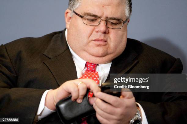 Agustín Carstens, Mexico�s finance minister, checks his mobile phone before speaking during the Bloomberg Economic Forum in Mexico City, Mexico, on...
