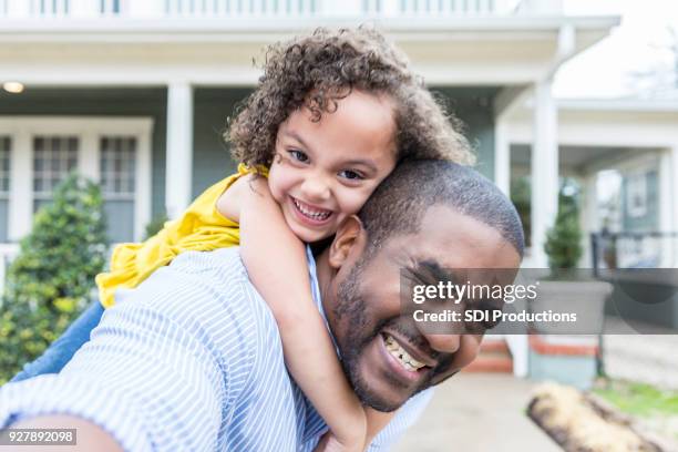 silly piggyback selfie of father and young daughter - new home pov stock pictures, royalty-free photos & images