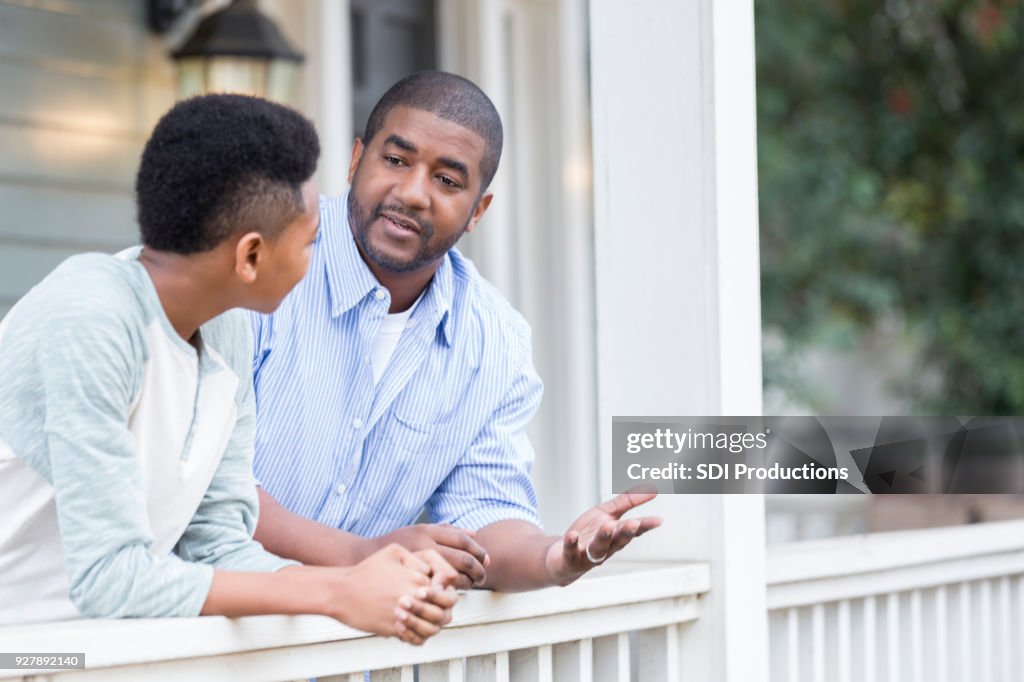 Padre e hijo en conversación seria porche
