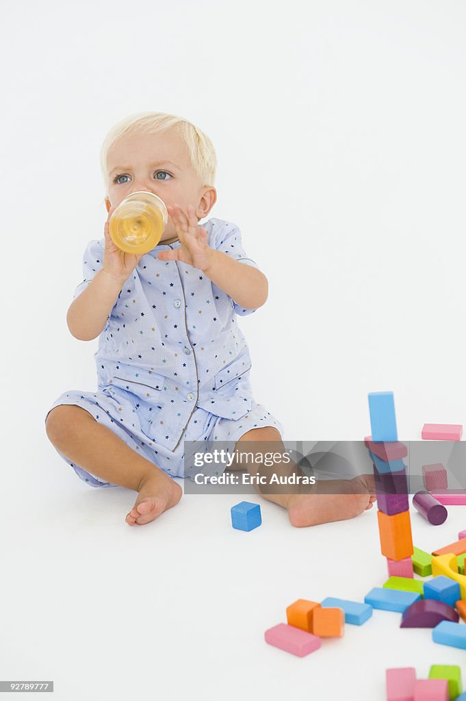 Baby boy drinking juice from a baby bottle