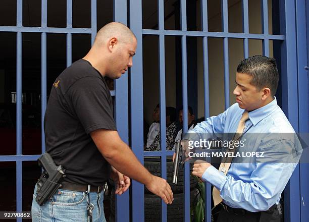 Member of Costa Rican Judicial Investigation Organisation checks on November 5 in San Jose the gun of an employee of the security company Avahuer...