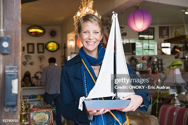 woman holding a toy boat in a store - toy sailboat stock pictures, royalty-free photos & images