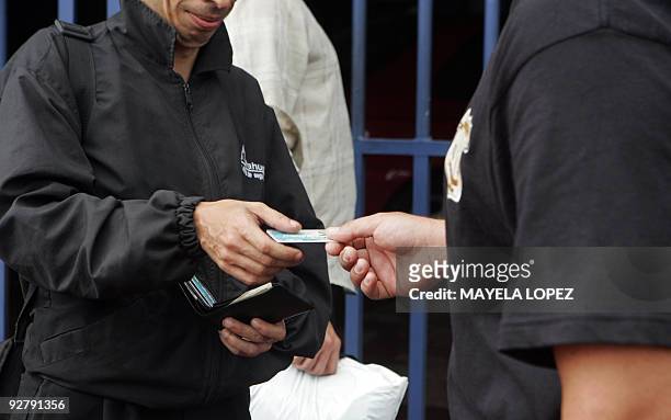 Member of Costa Rican Judicial Investigation Organisation checks on November 5 in San Jose the ID of an employee of the security company Avahuer...