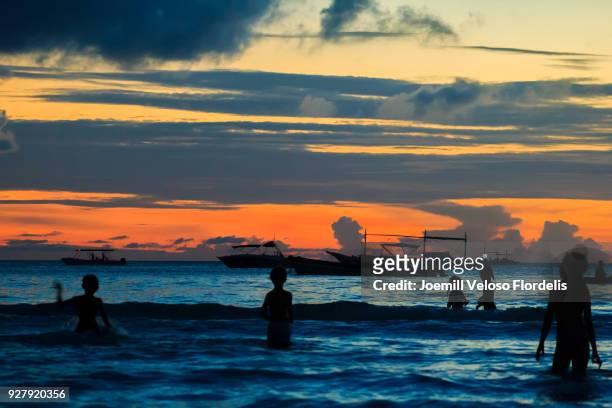 kids swimming at sunset in boracay island (malay, aklan, philippines) - joemill flordelis stock pictures, royalty-free photos & images